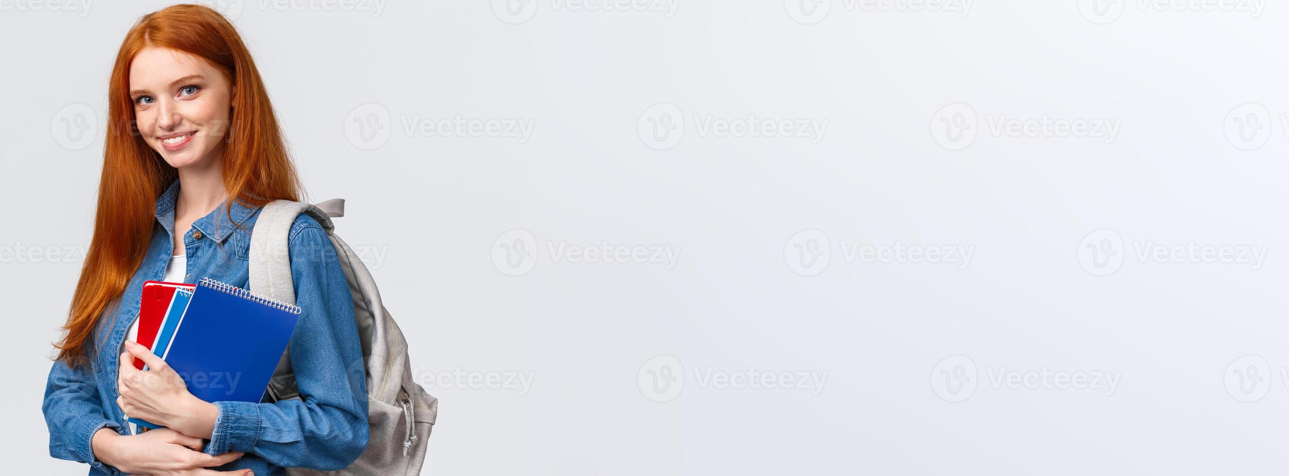 Time to school. Lovely cheerful modern redhead female with backpack holding notebooks heading college, smiling amused, heading back to class after break, standing white background photo