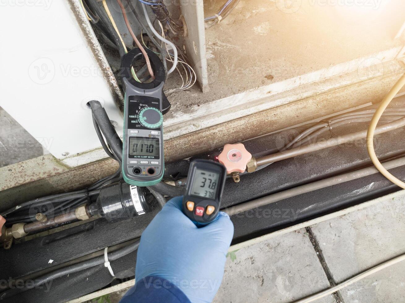 Checking and measuring temperature using a thermo gun in the refrigeration system in HVAC air conditioning. Refrigeration check using thermo gun with concept professional hvac service. photo