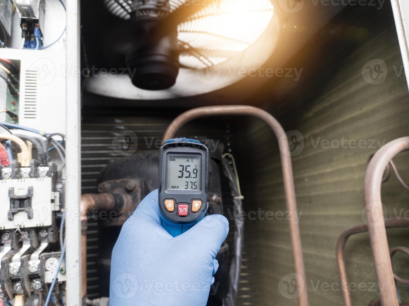 Checking and measuring temperature using a thermo gun in the refrigeration system in HVAC air conditioning. Refrigeration check using thermo gun with concept professional hvac service. photo