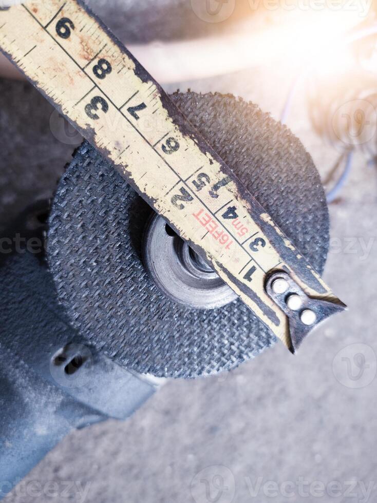 Checking the condition of the cutting grinding wheel by a ruler. photo
