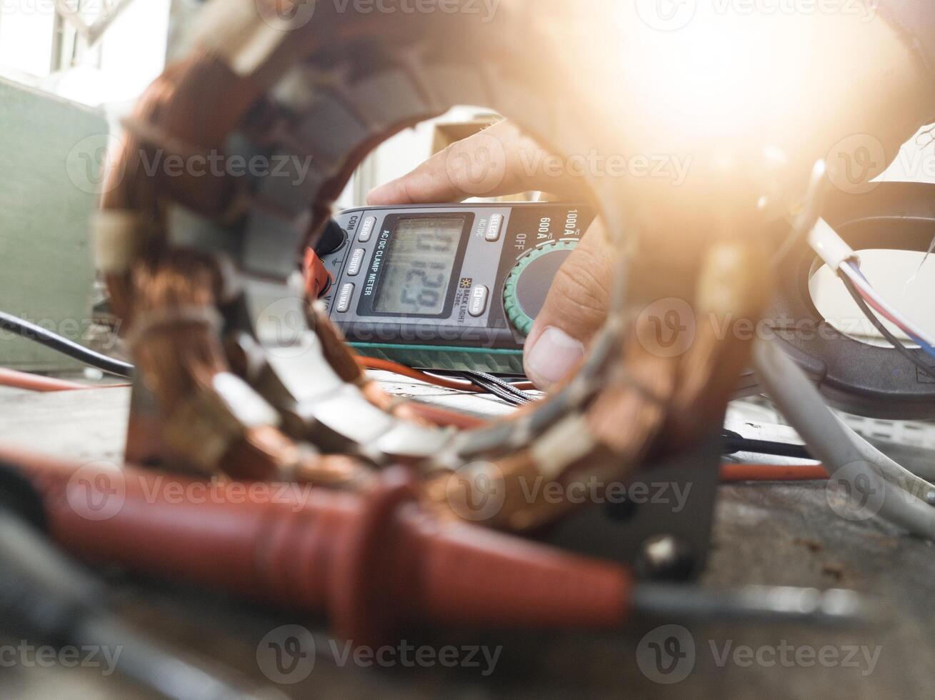 Motor winding repair concept using a multi tester to check and analyze damage. photo