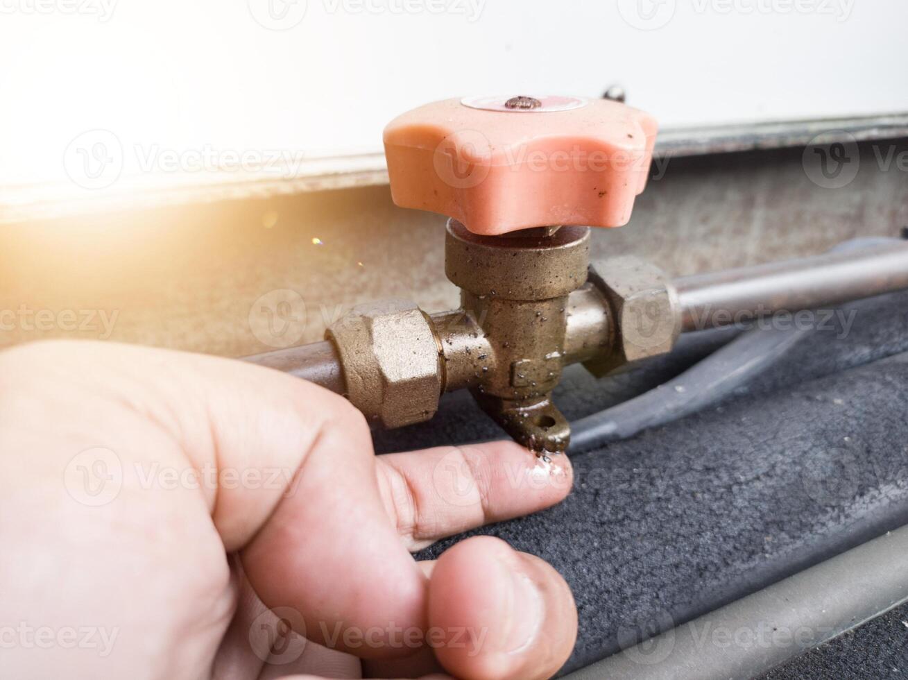Checking for refrigerant gas leaks in outdoor HVAC systems. check oil leaks on cut off valve. photo