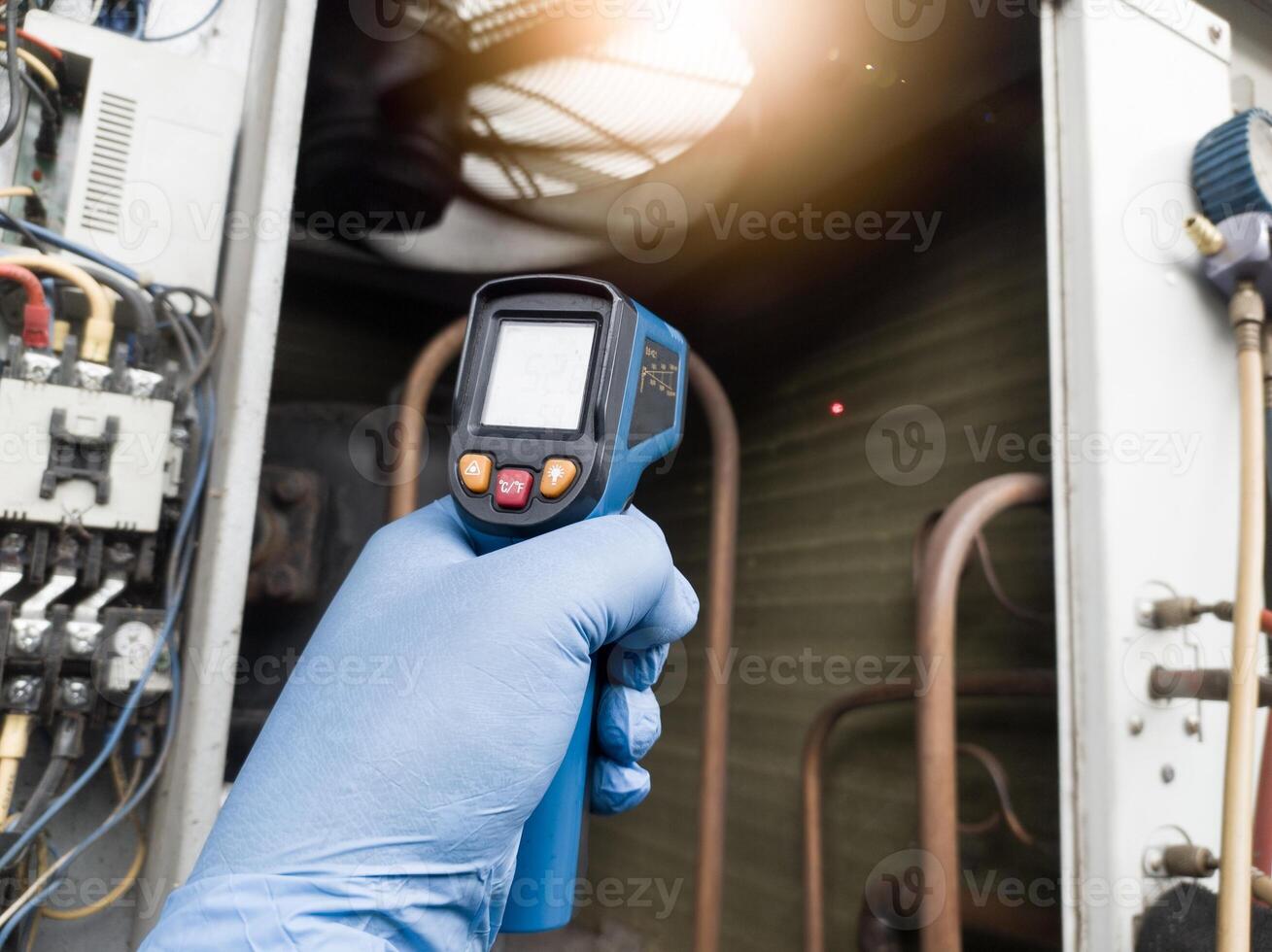 Checking and measuring temperature using a thermo gun in the refrigeration system in HVAC air conditioning. Refrigeration check using thermo gun with concept professional hvac service. photo