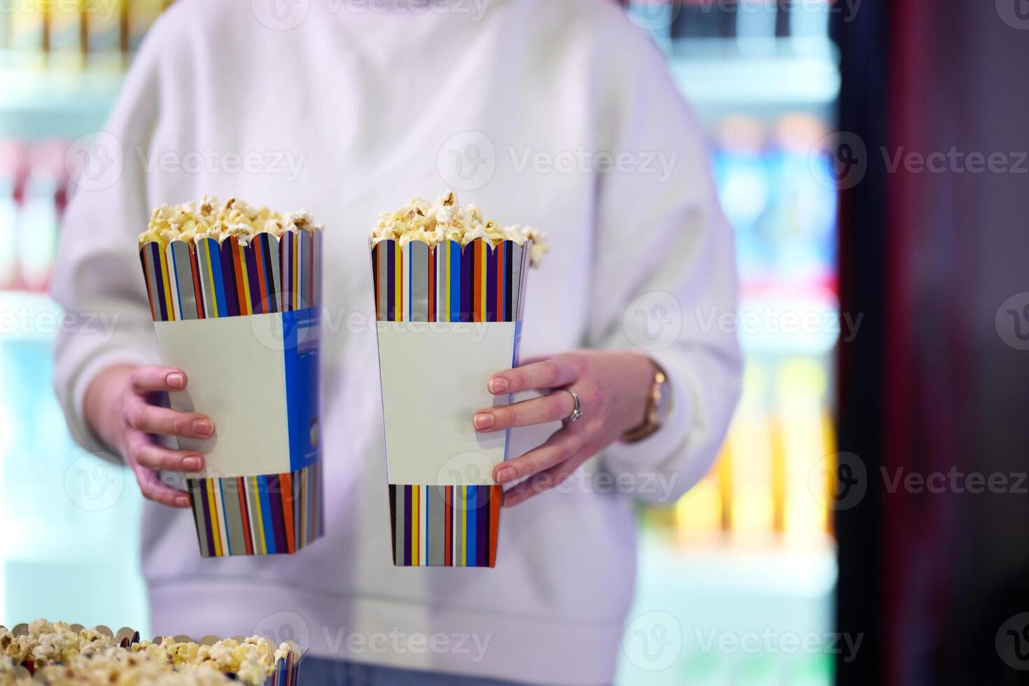 A vendor stands outside the cinema, holding freshly popped popcorn to sell to moviegoers before they enter the theater photo