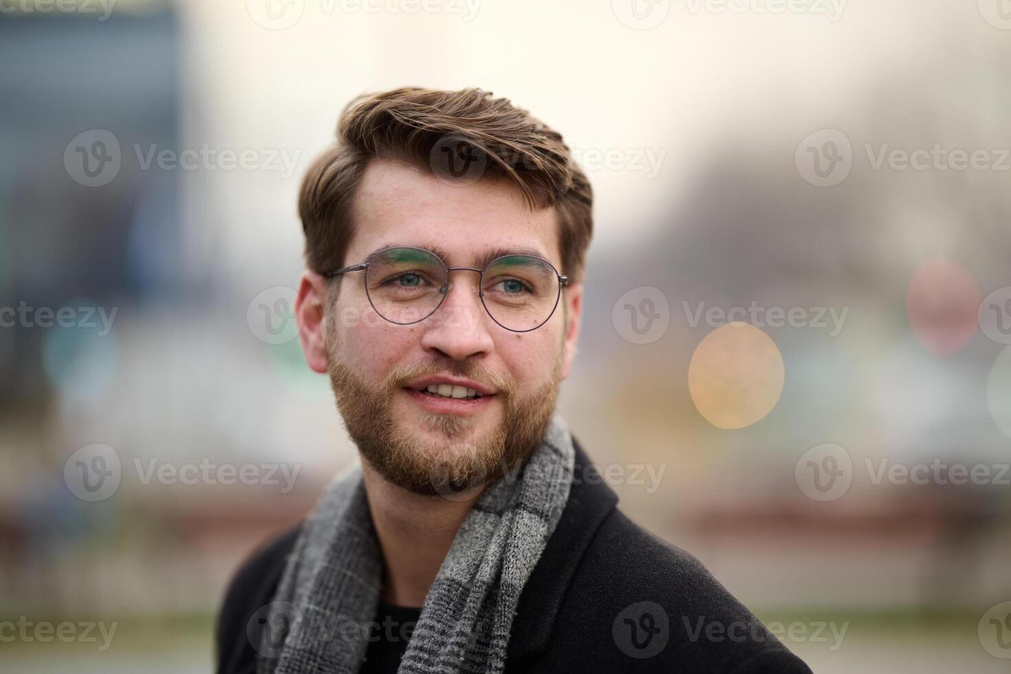 A handsome young man, dressed in a stylish suit, tie, and glasses, exudes the appearance of a serious and confident businessman photo