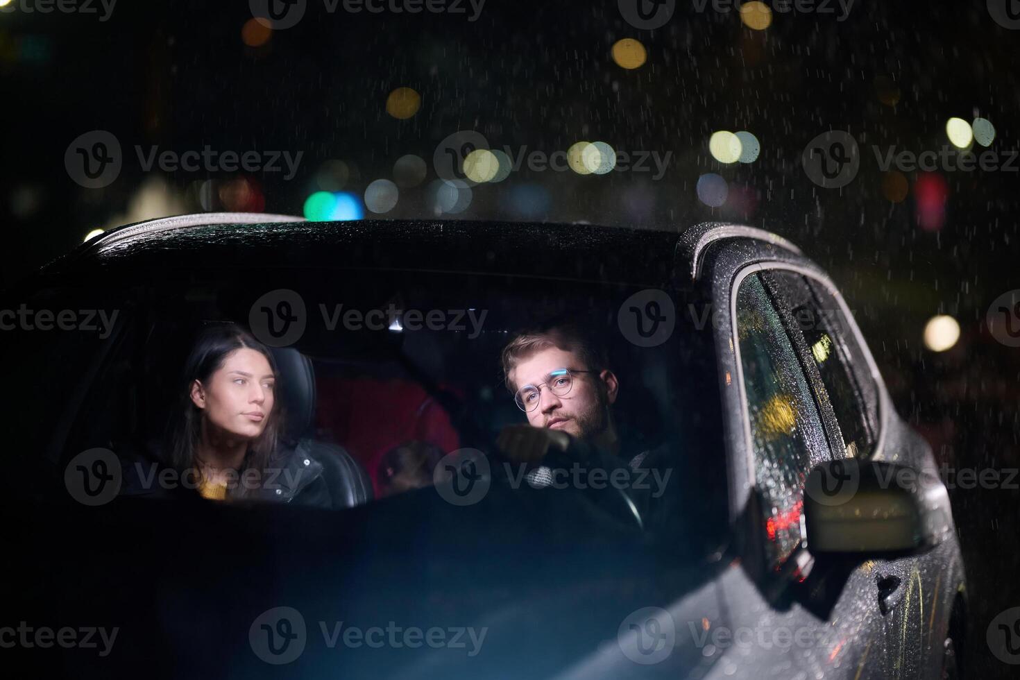 In the midst of a nighttime journey, a happy family enjoys playful moments inside a car as they travel through rainy weather, illuminated by the glow of headlights, laughter, and bonding photo