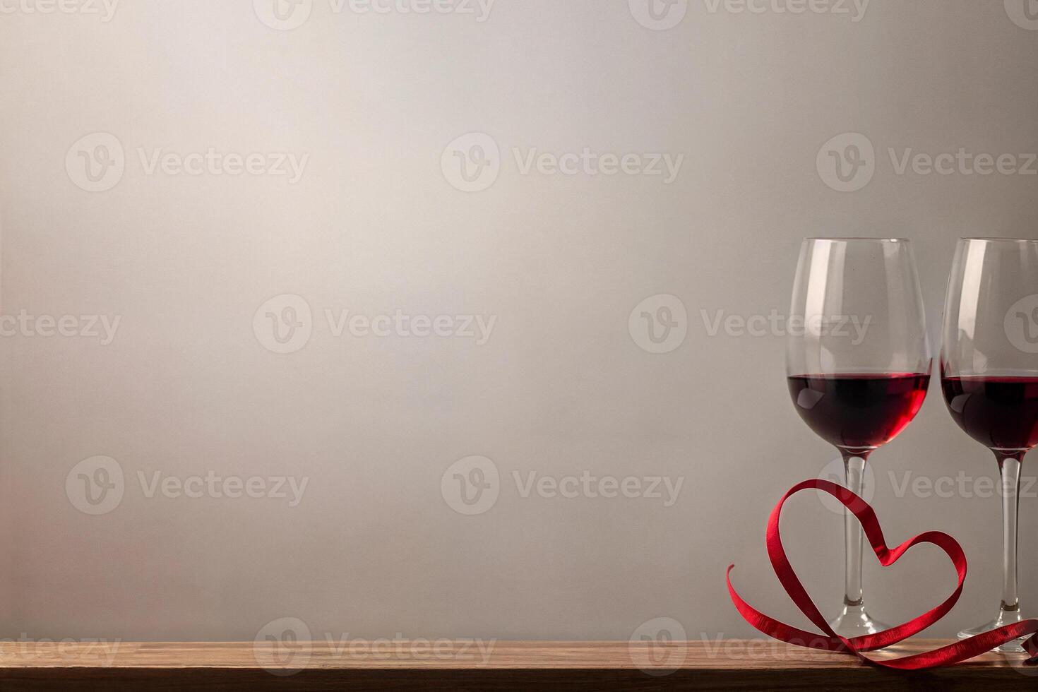 valentine's day, two glasses of champagne, red heart ribbon on a wooden table with space for text on a light background photo
