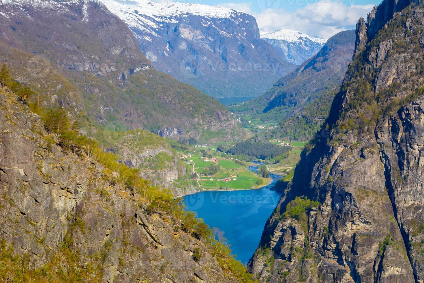 View on Norwegian fjord village in the distance, looking through rocks and mountains. photo