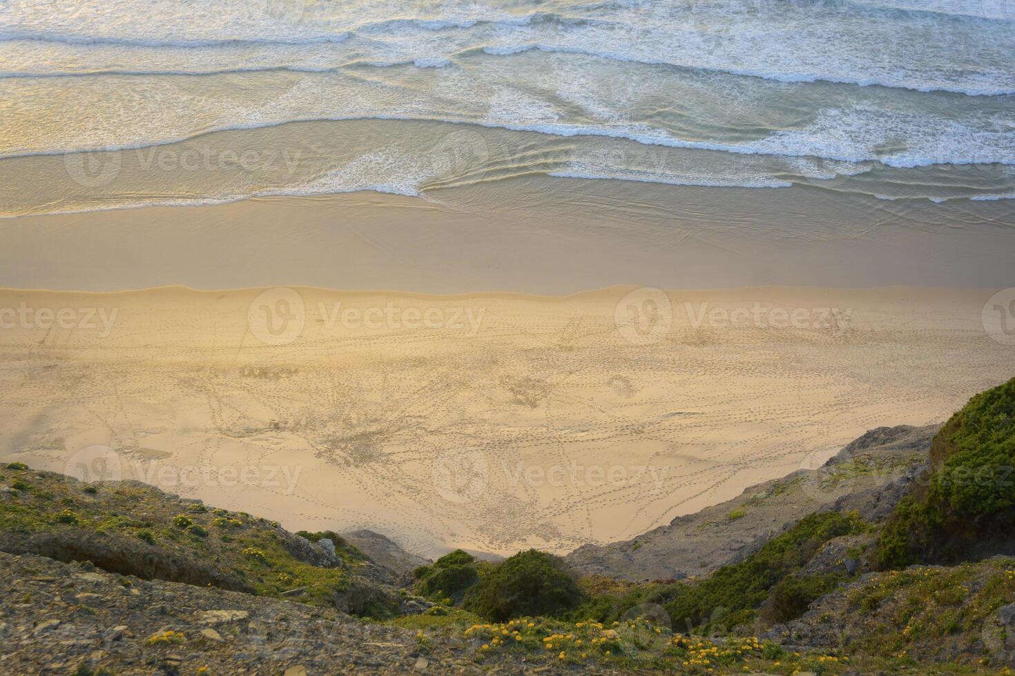 View on empty beach from a cliff. Location Bordeira on the Algarve coast in Portugal photo