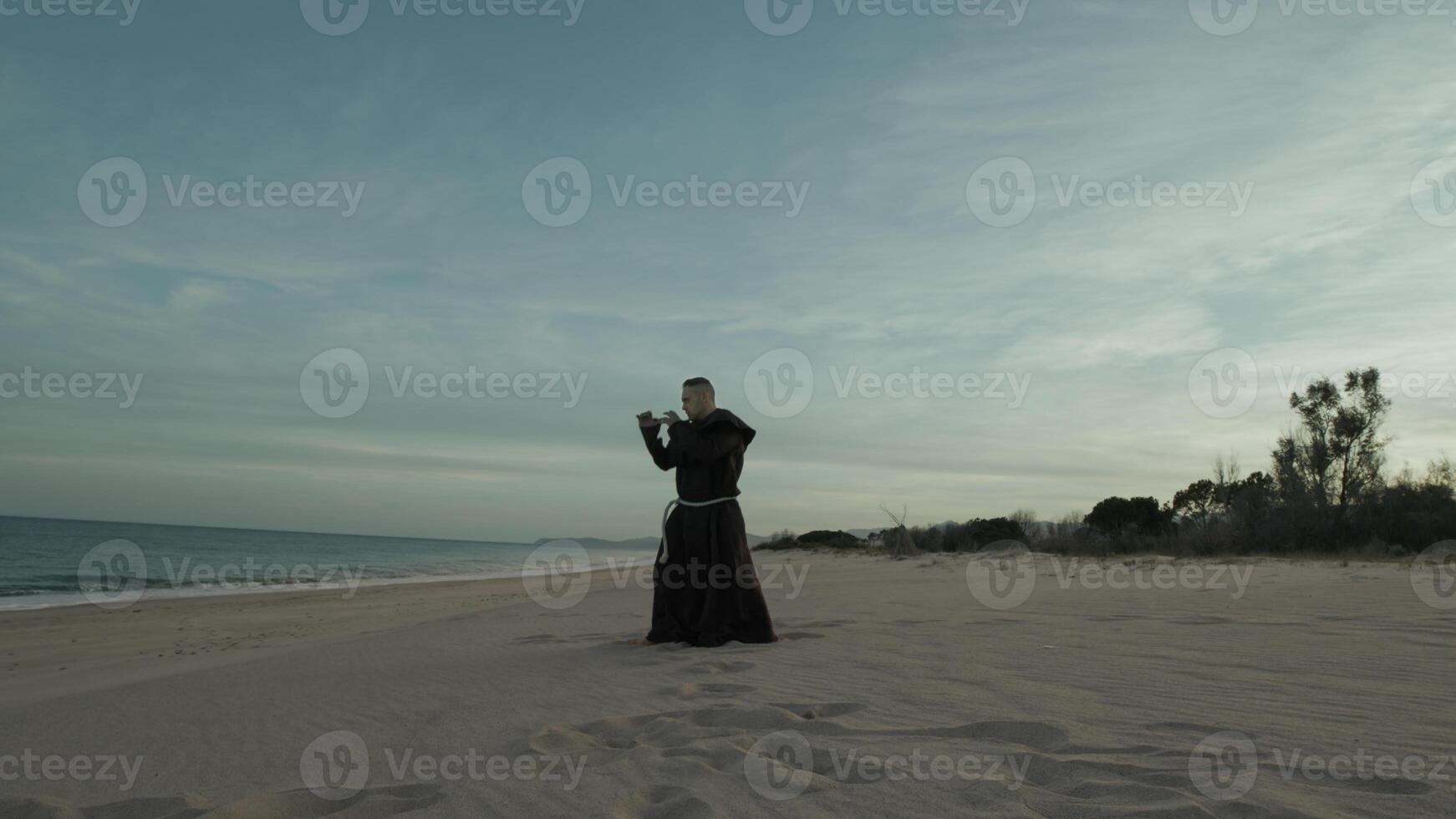 Monk Athlete Does Karate Sport To Defend The Weakest On The Beach photo