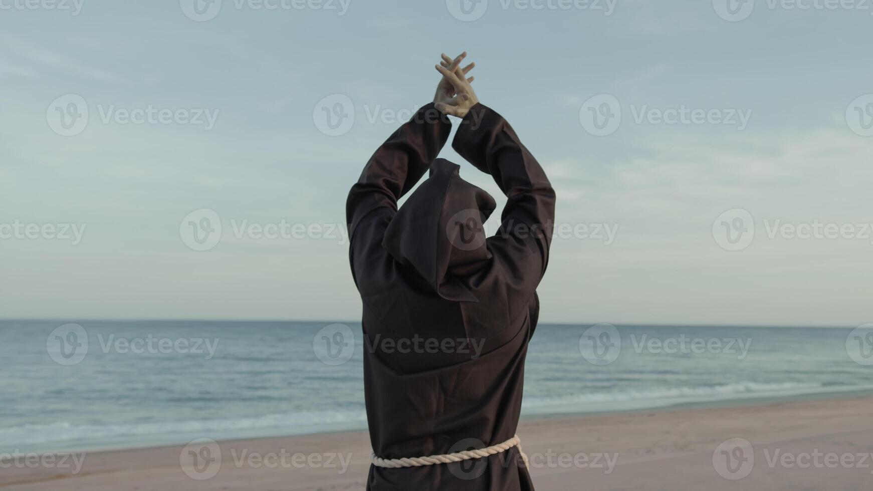 Religious Monk With Prays Towards The Sea With Open Arms photo