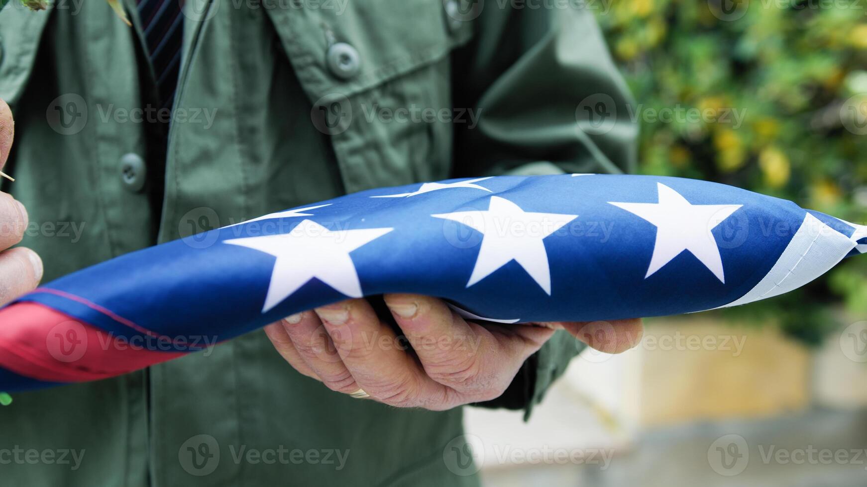 Folded Flag In Commemoration Of American Fallen Held In Hand photo