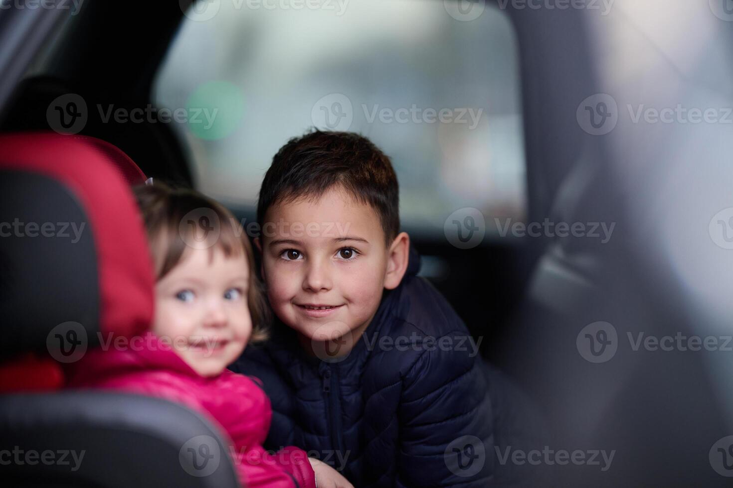 A young brother and sister enjoying a car ride together, immersed in the adventure of travel photo