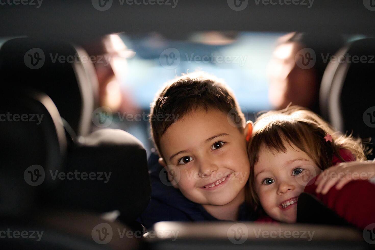 A young brother and sister enjoying a car ride together, immersed in the adventure of travel photo