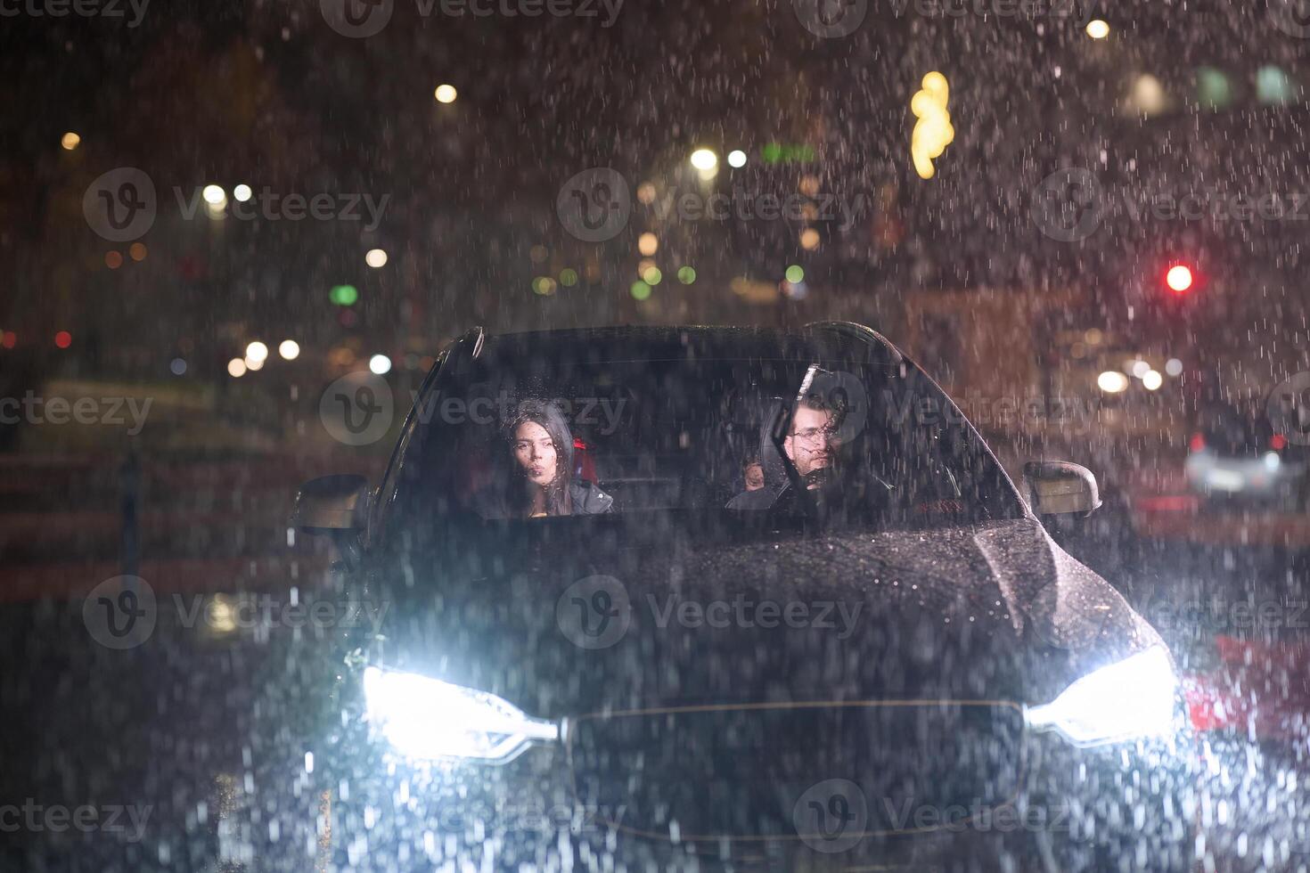 In the midst of a nighttime journey, a happy family enjoys playful moments inside a car as they travel through rainy weather, illuminated by the glow of headlights, laughter, and bonding photo