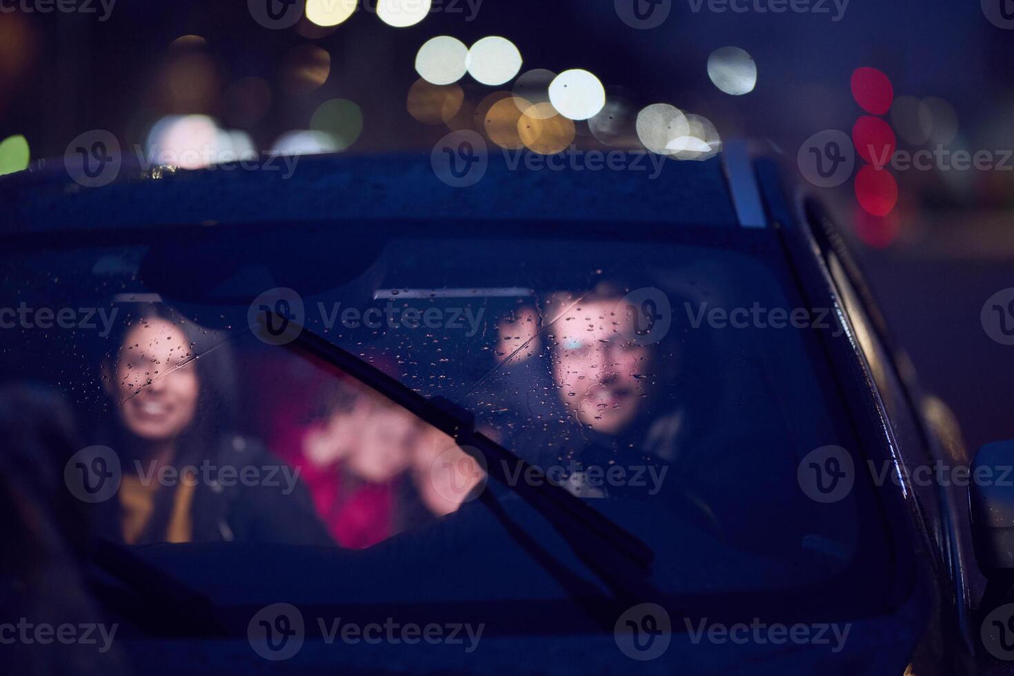 In the nighttime hours, a happy family enjoys playful moments together inside a car as they journey on a nocturnal road trip, illuminated by the glow of headlights and filled with laughter and joy photo
