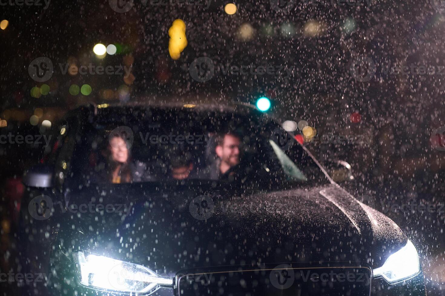 In the midst of a nighttime journey, a happy family enjoys playful moments inside a car as they travel through rainy weather, illuminated by the glow of headlights, laughter, and bonding photo