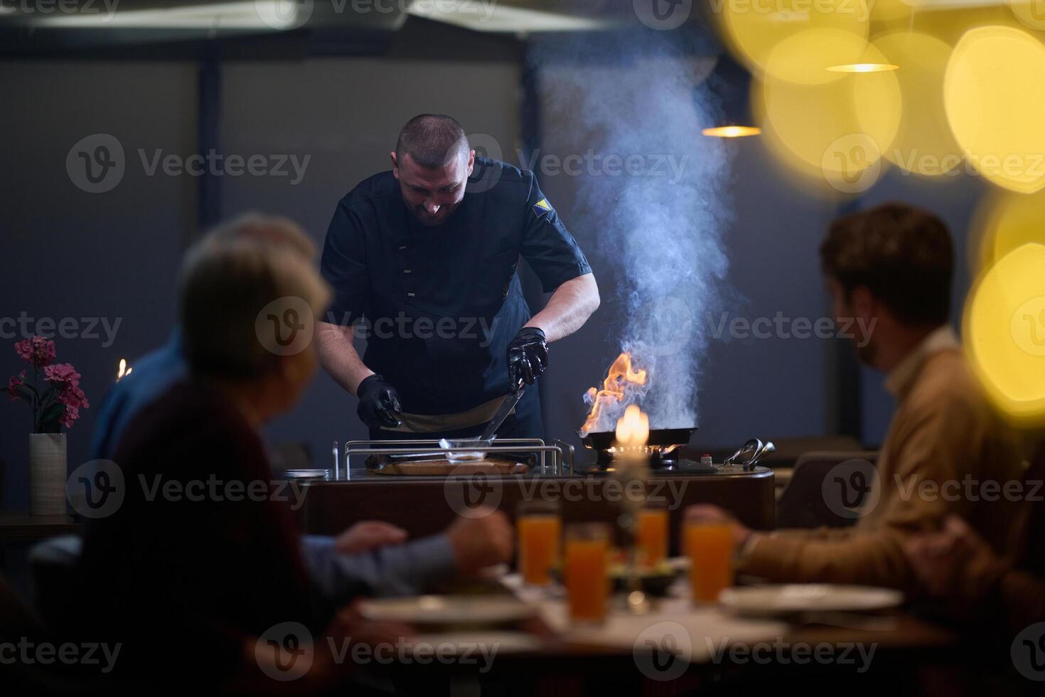 In a restaurant setting, a professional chef presents a sizzling steak cooked over an open flame, while an European Muslim family eagerly awaits their iftar meal during the holy month of Ramadan photo