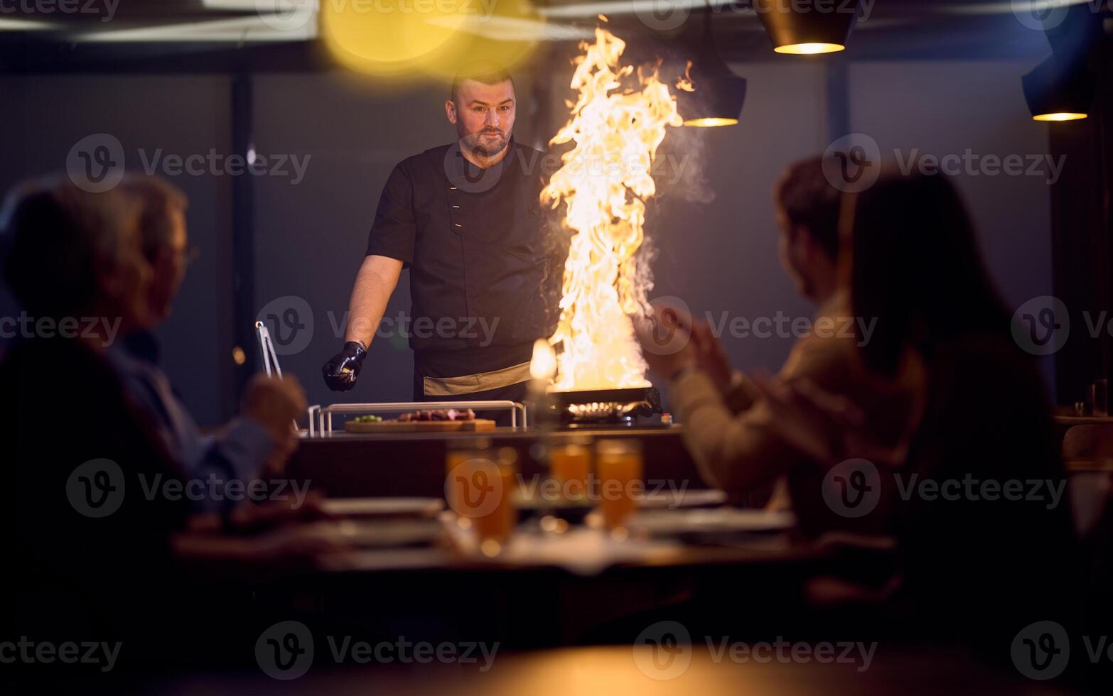 In a restaurant setting, a professional chef presents a sizzling steak cooked over an open flame, while an European Muslim family eagerly awaits their iftar meal during the holy month of Ramadan photo