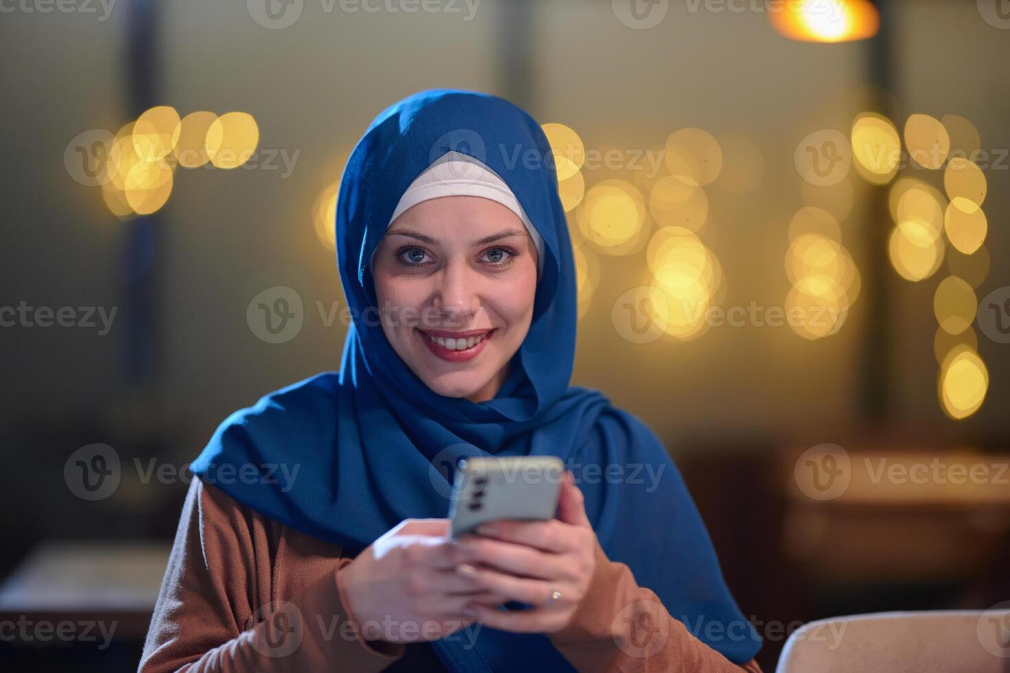 A beautiful European Muslim woman, adorned with a hijab, utilizes her smartphone to swiftly prepare for iftar during the sacred month of Ramadan, embodying the blend of tradition and modernity in her photo