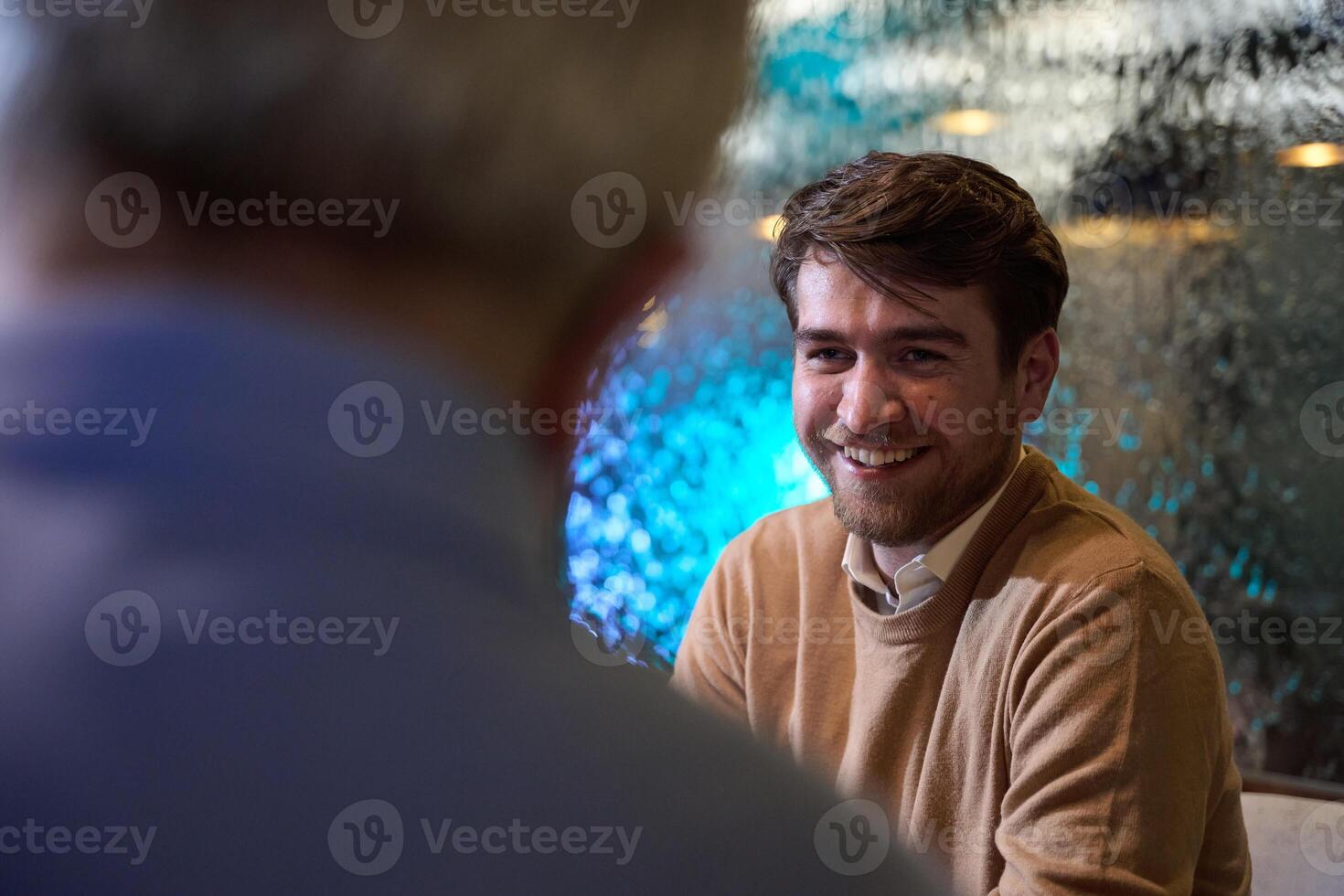 A son and his elderly father engage in heartfelt conversation while patiently awaiting their iftar meal, fostering intergenerational bonding and cherished moments of family connection photo