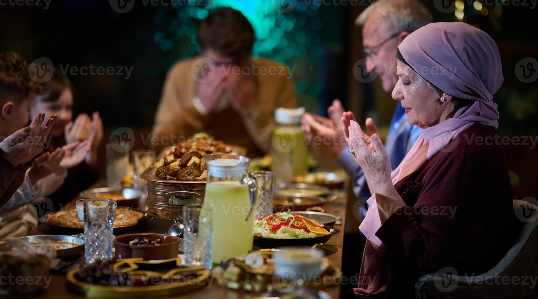 In a modern restaurant setting, a European Islamic family comes together for iftar during Ramadan, engaging in prayer before the meal, uniting tradition and contemporary practices in a celebration of photo