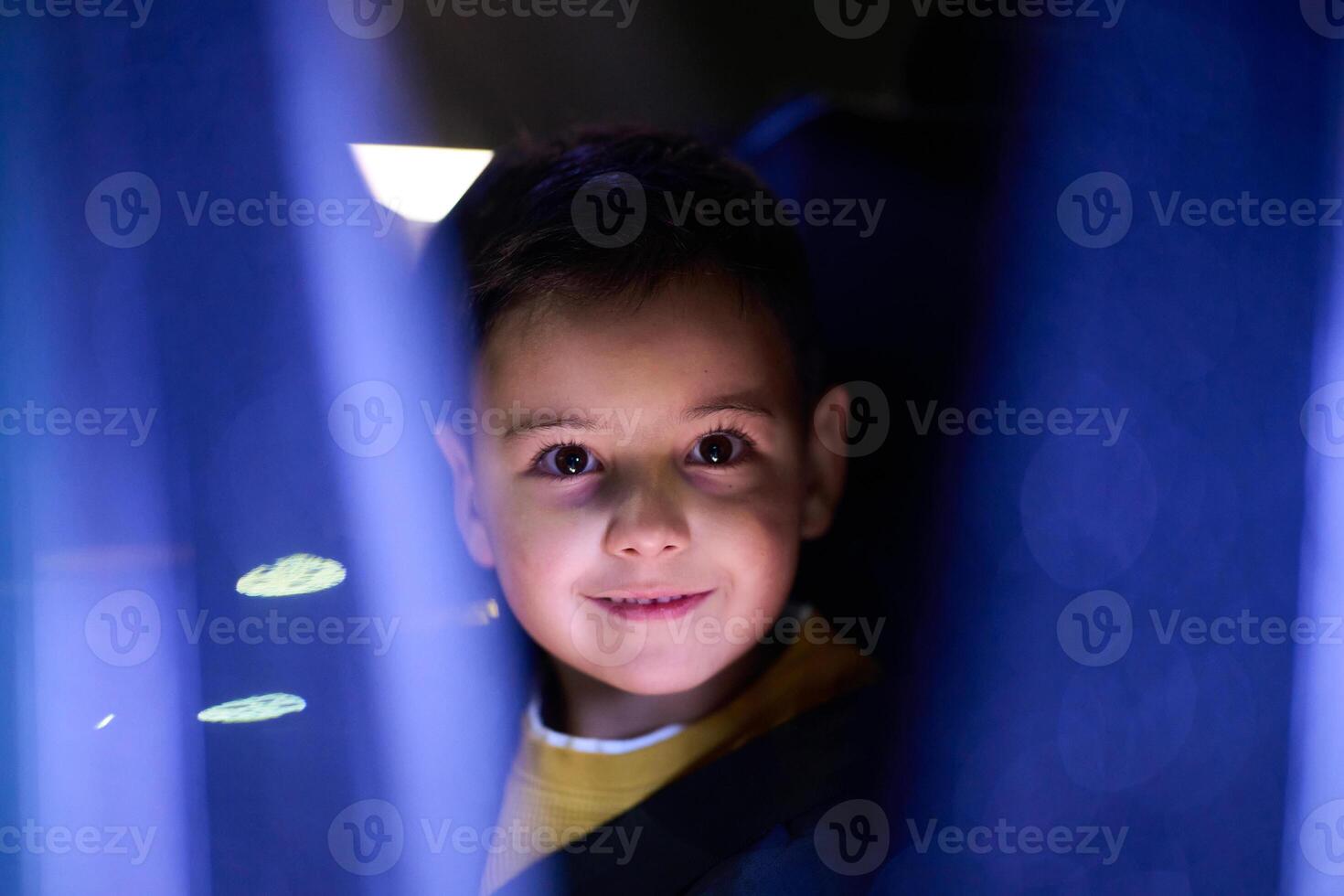 A young boy enjoys a car ride, captured through the window, as he observes the passing scenery. photo