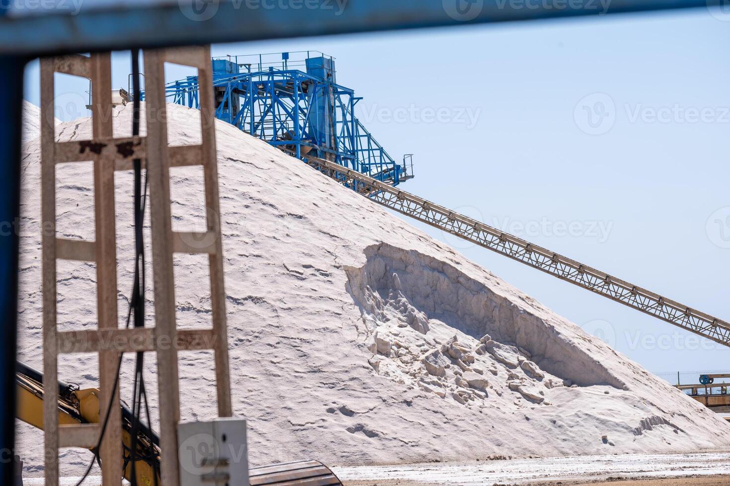 Industrial machinery crowns a salt pile, with conveyors and structures framing the busy scene of salt processing. photo