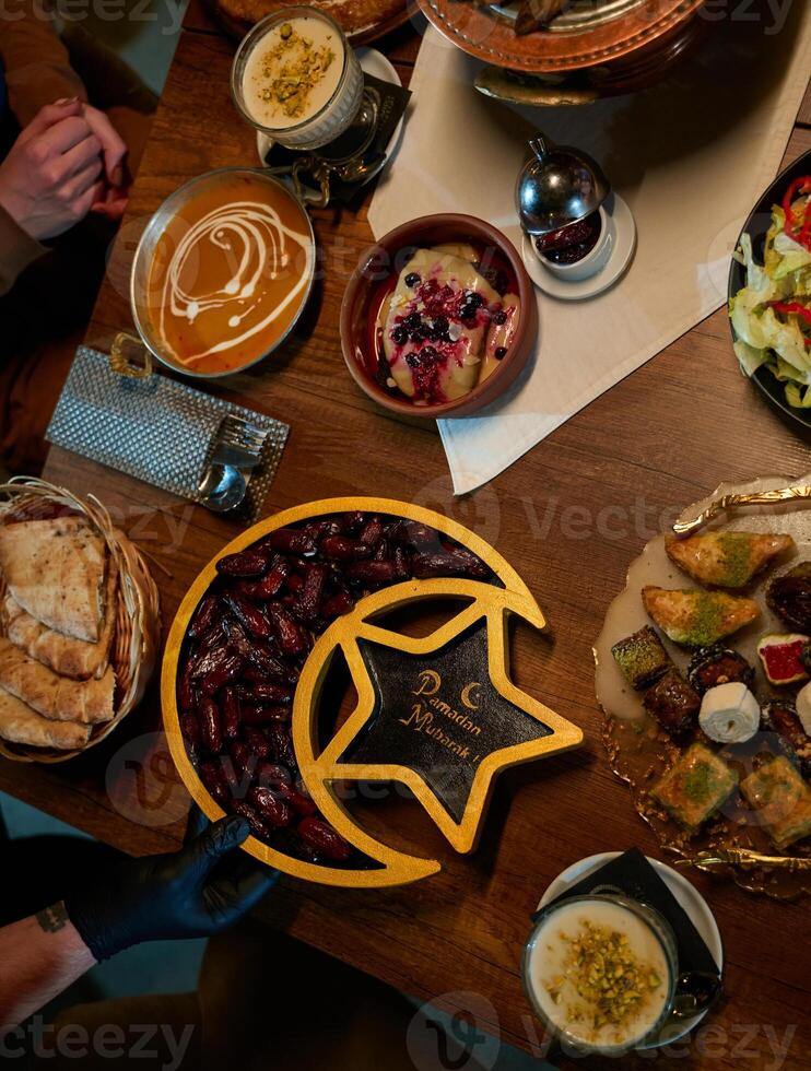 In this captivating aerial view, delicious food adorned with Ramadan decorations, including dates and meat, awaits the arrival of an European Islamic family, promising a festive and flavorful iftar photo