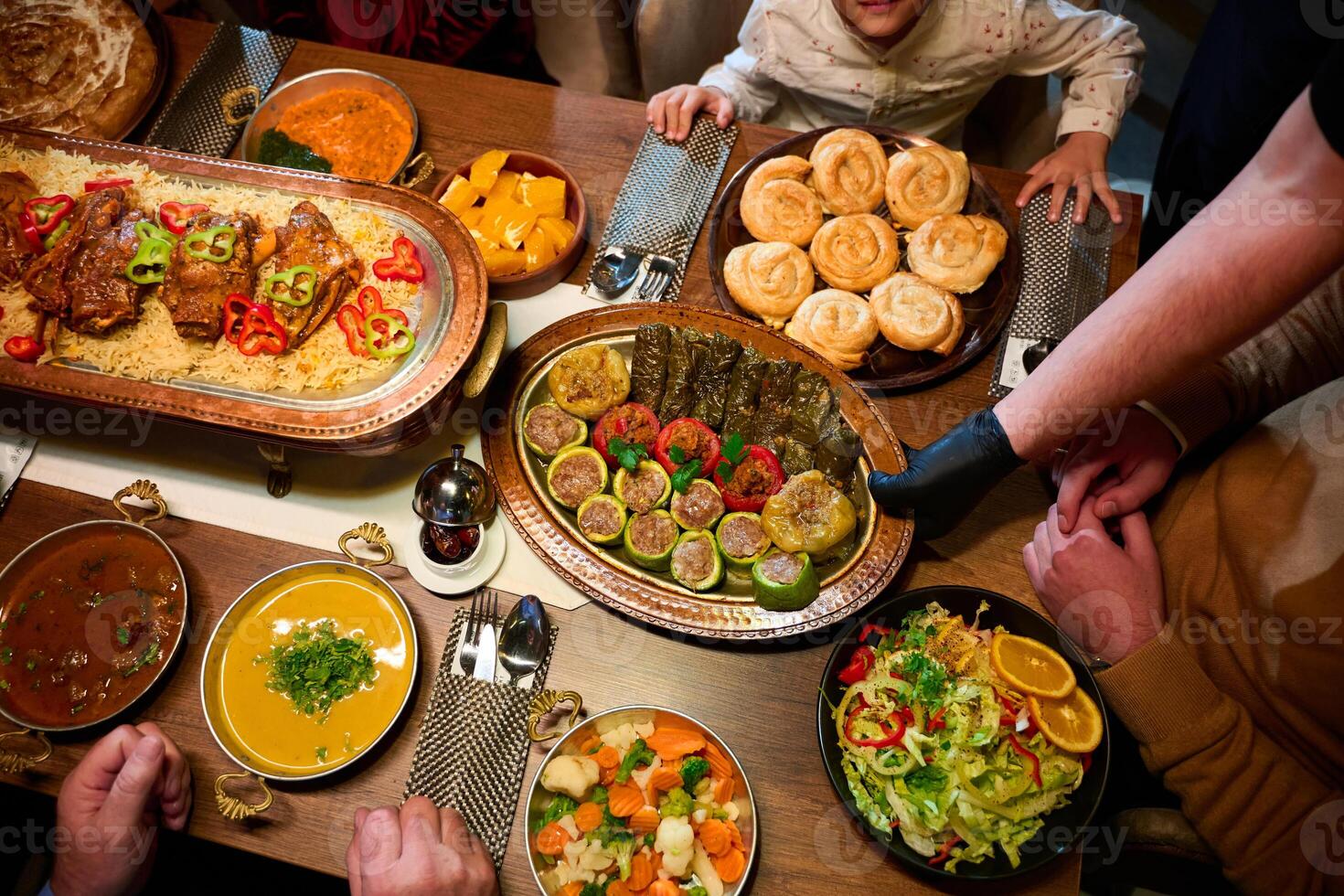 In this captivating aerial view, delicious food adorned with Ramadan decorations, including dates and meat, awaits the arrival of an European Islamic family, promising a festive and flavorful iftar photo