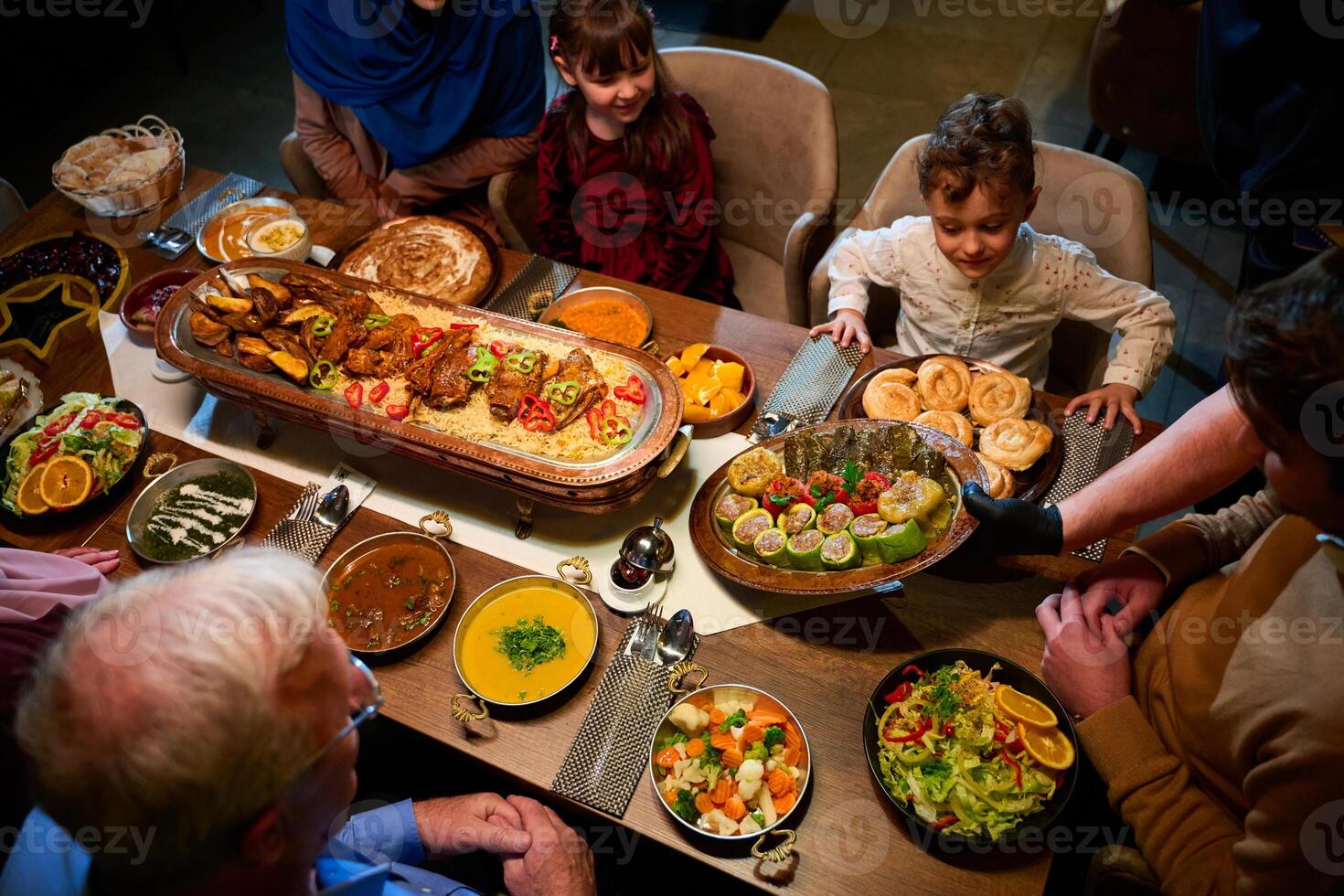 In this captivating aerial view, delicious food adorned with Ramadan decorations, including dates and meat, awaits the arrival of an European Islamic family, promising a festive and flavorful iftar photo