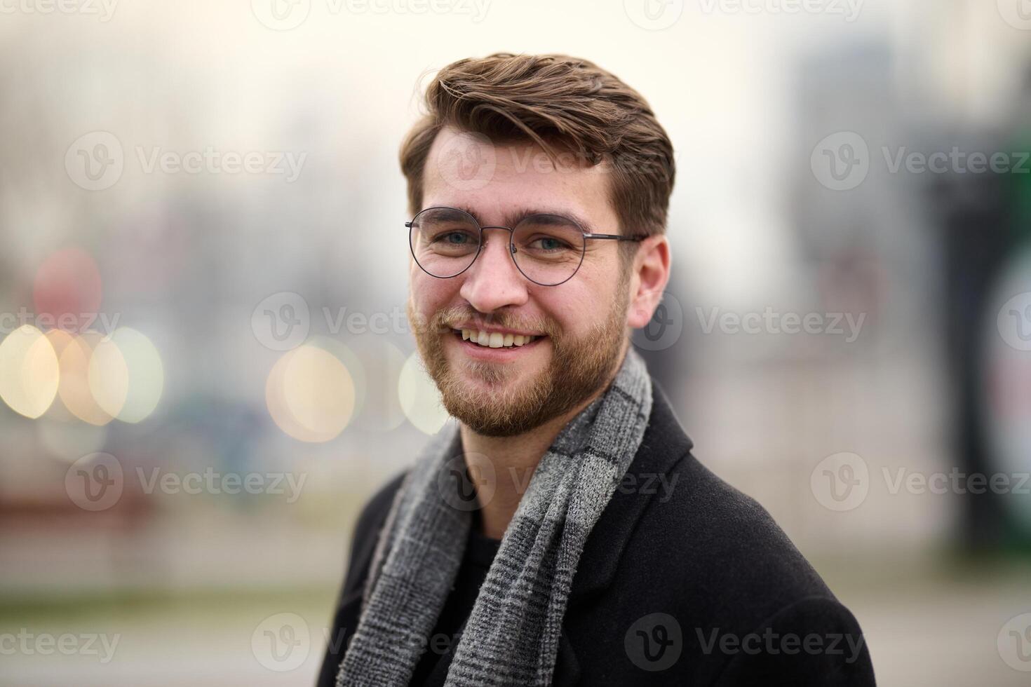 A handsome young man, dressed in a stylish suit, tie, and glasses, exudes the appearance of a serious and confident businessman photo