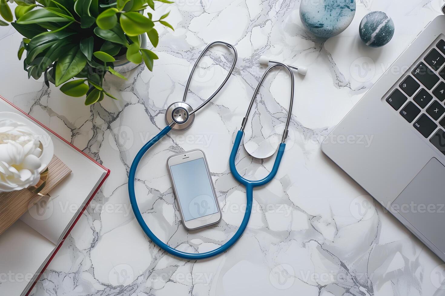 A close up of a laptop, phone, and stethoscope on a table photo