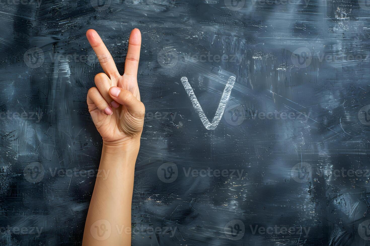 Person writing 'v' on blackboard with fingers photo