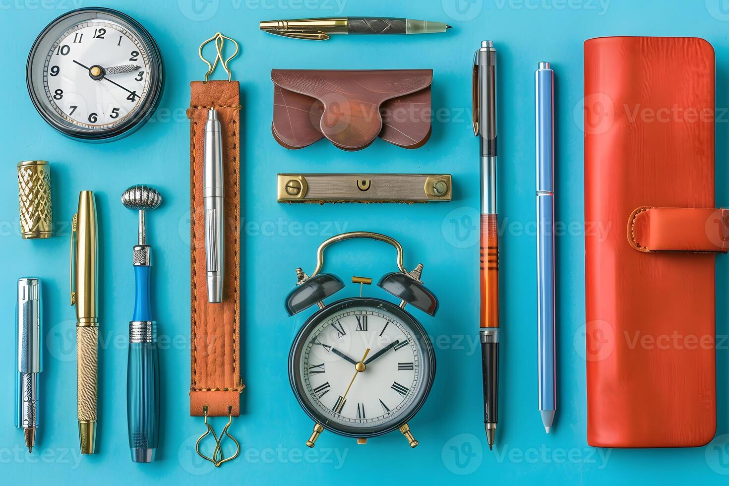 A close up of a clock, pen, pencil, and other office supplies photo