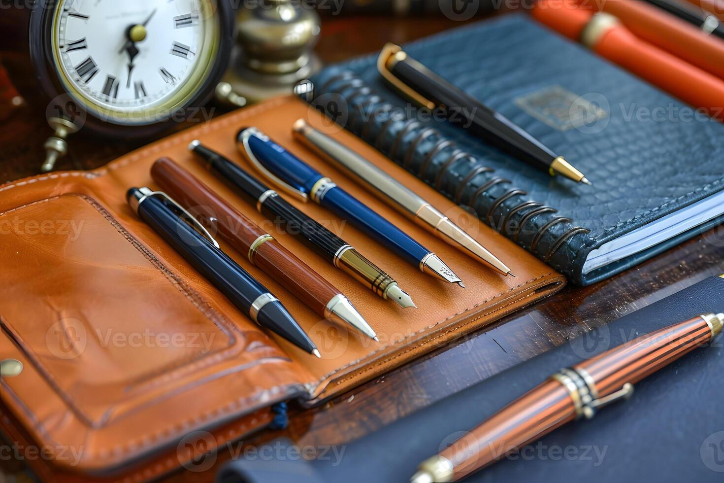 Many pens and notebooks on a table with a clock photo