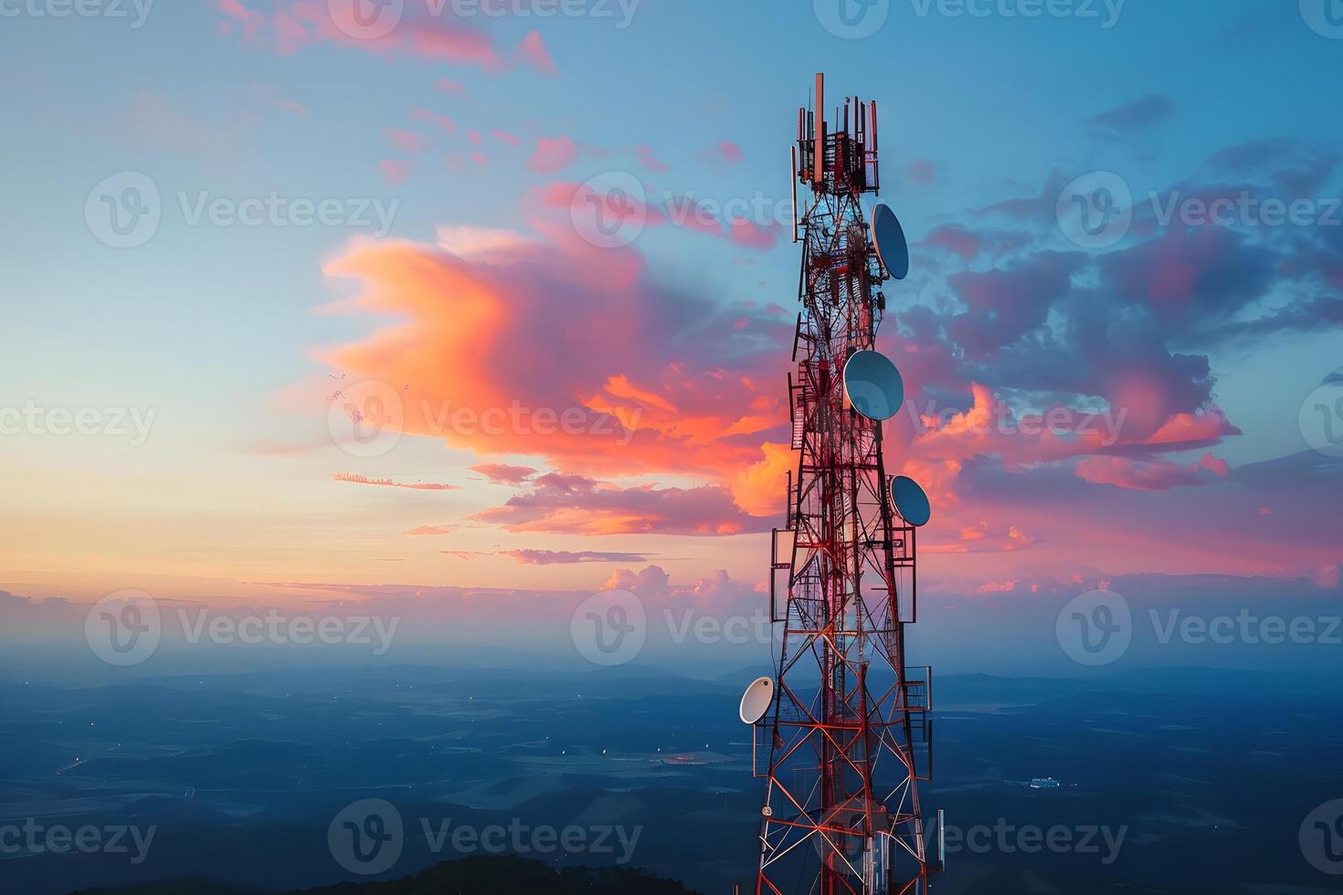 A cell tower silhouetted against a sunset sky photo