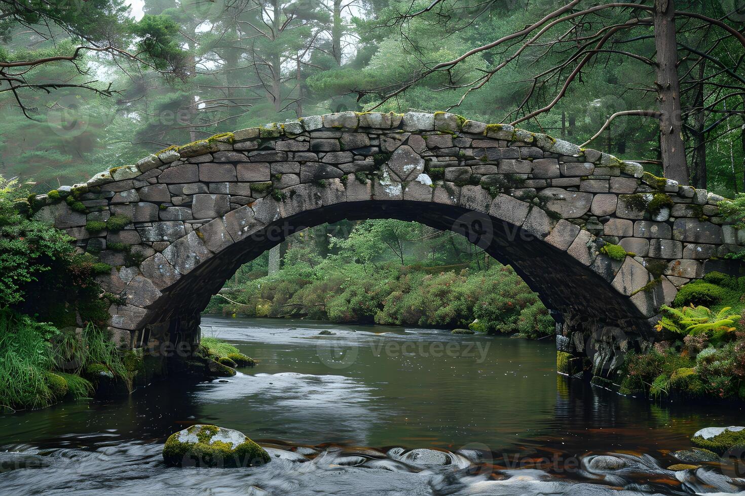 Stone bridge crossing stream in forest photo