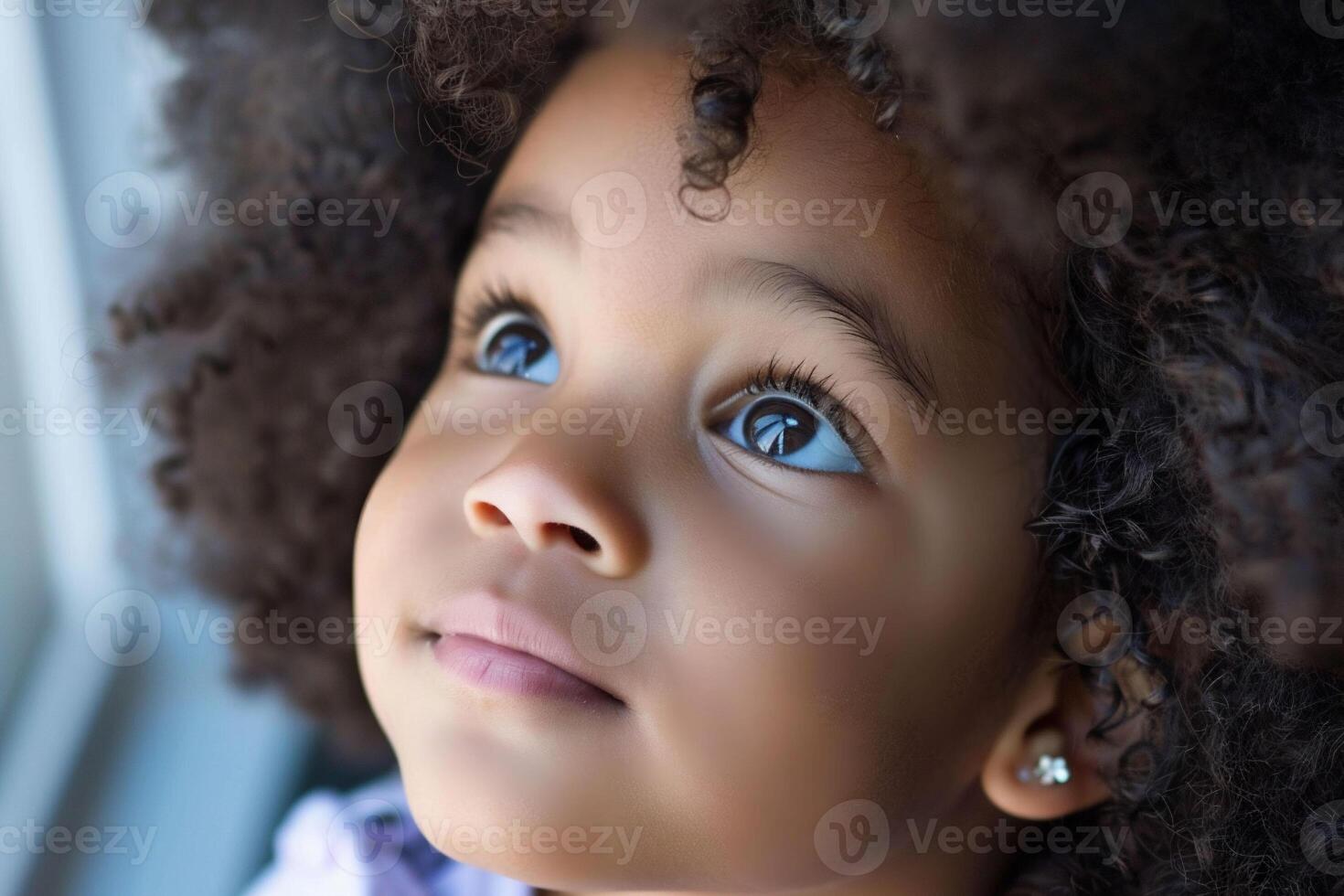 An adorable African American toddler with curly locks exudes joy with sparkling eyes and a dreamy smile, a picture-perfect moment of pure happiness. photo