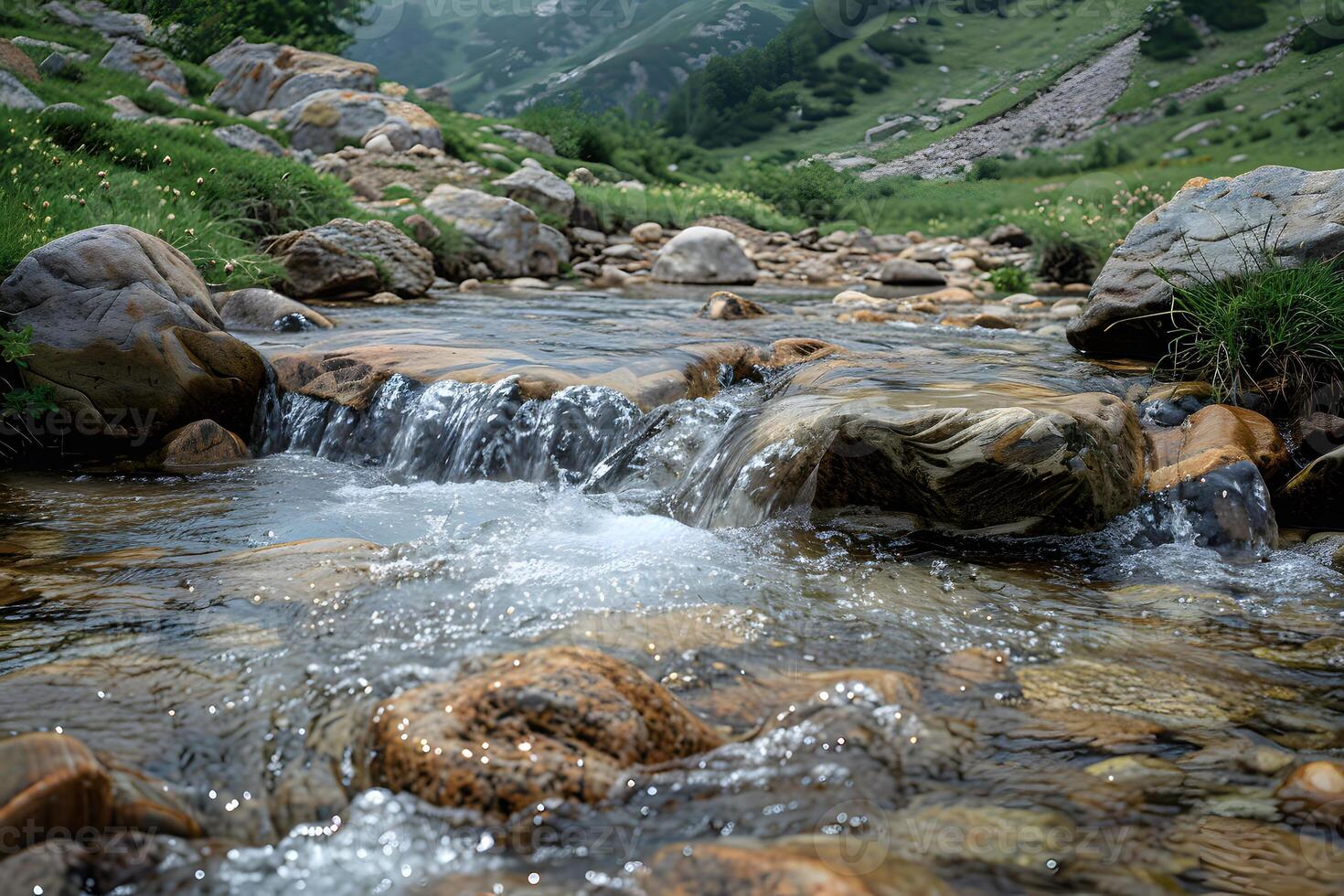 A stream of water flowing through a rocky mountain valley photo