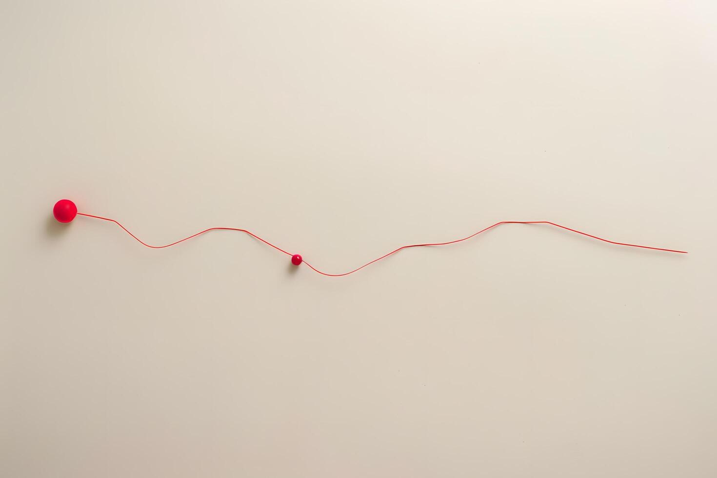 A red string with a red ball on it photo