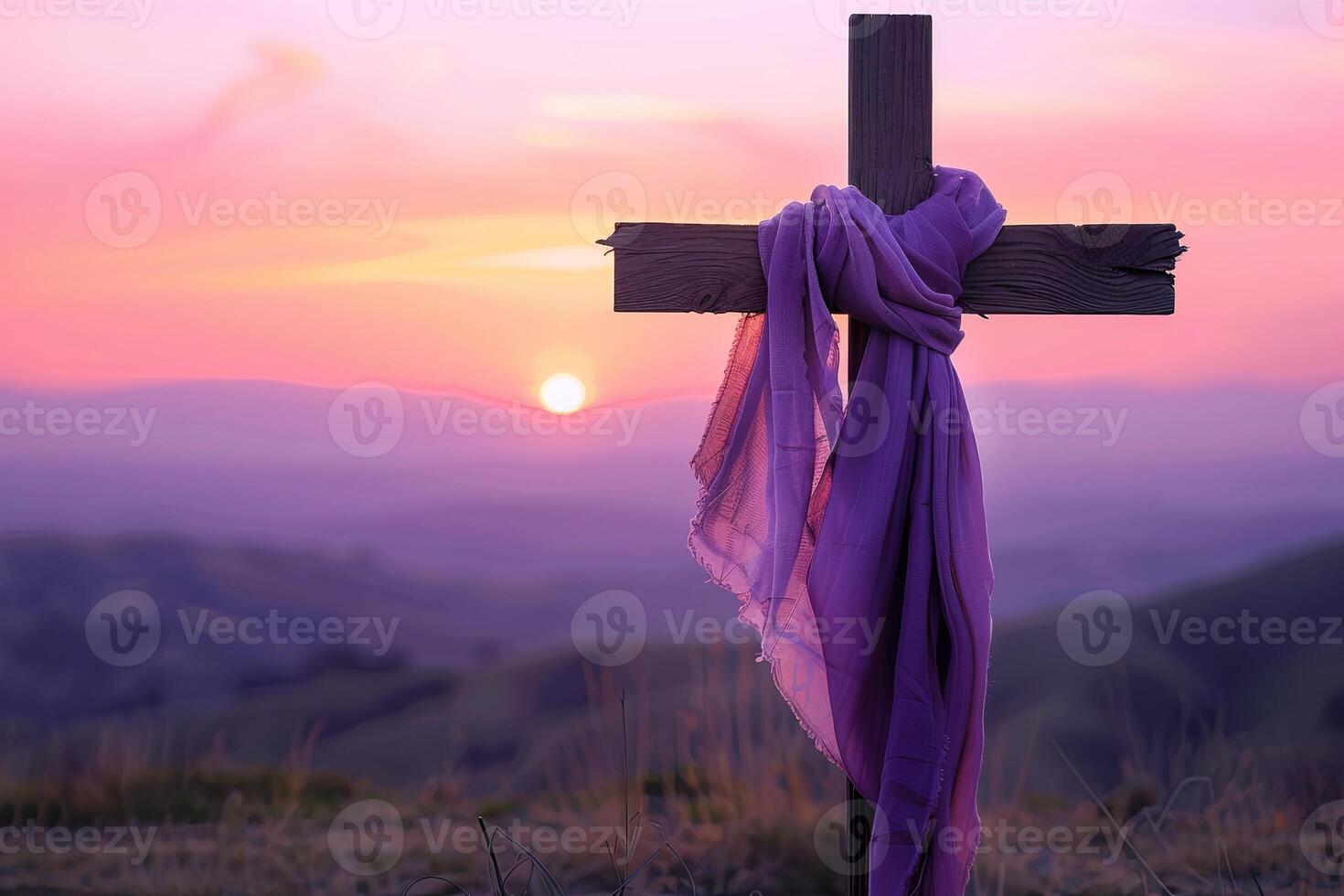 Luxurious purple-clothed wooden cross against sunset hills photo