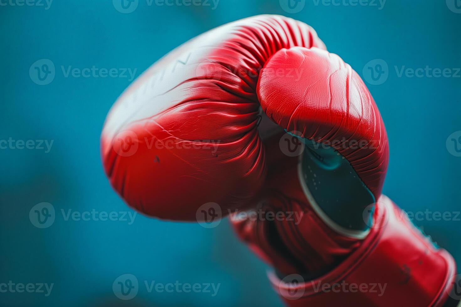 Red boxing glove, blue background close-up photo