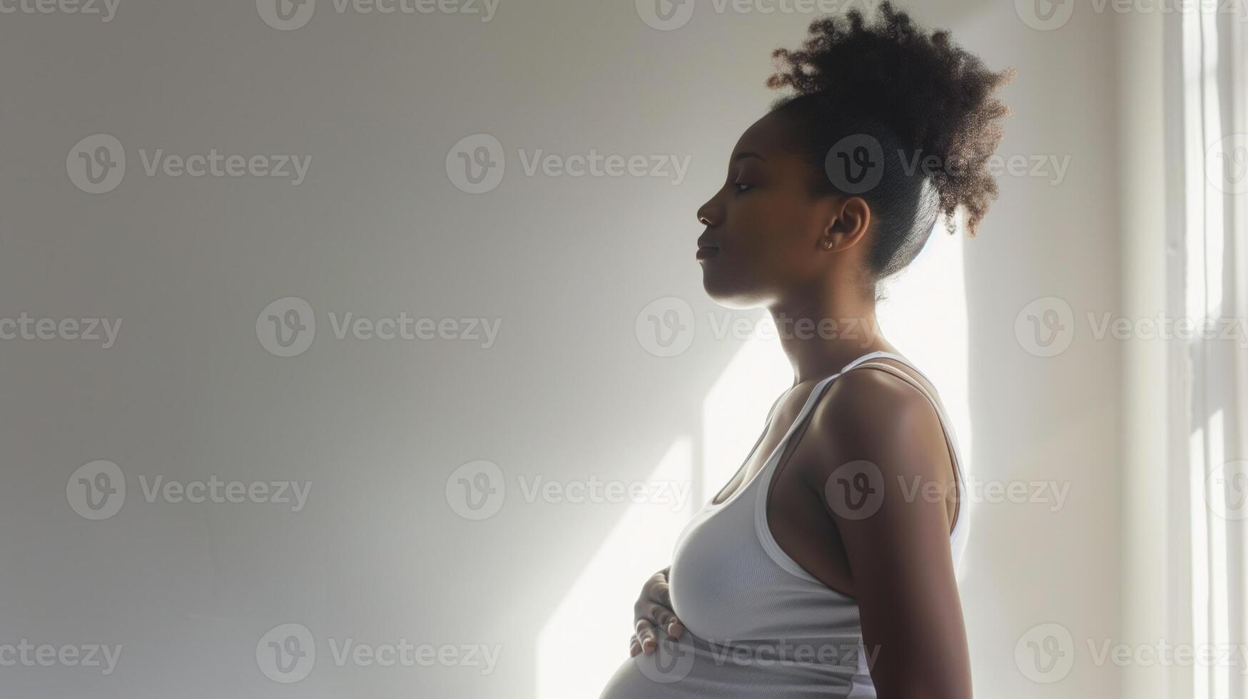 Pregnant black woman in a white tank top in profile photo