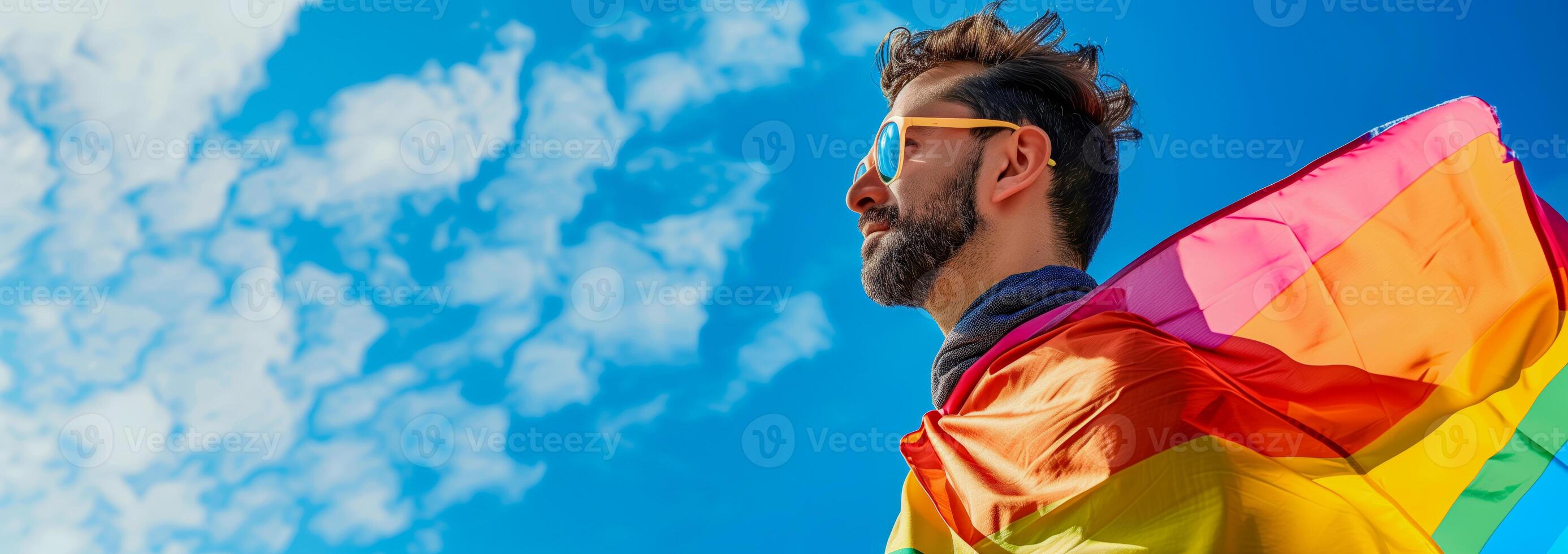 Bearded man in sunglasses holding rainbow flag photo