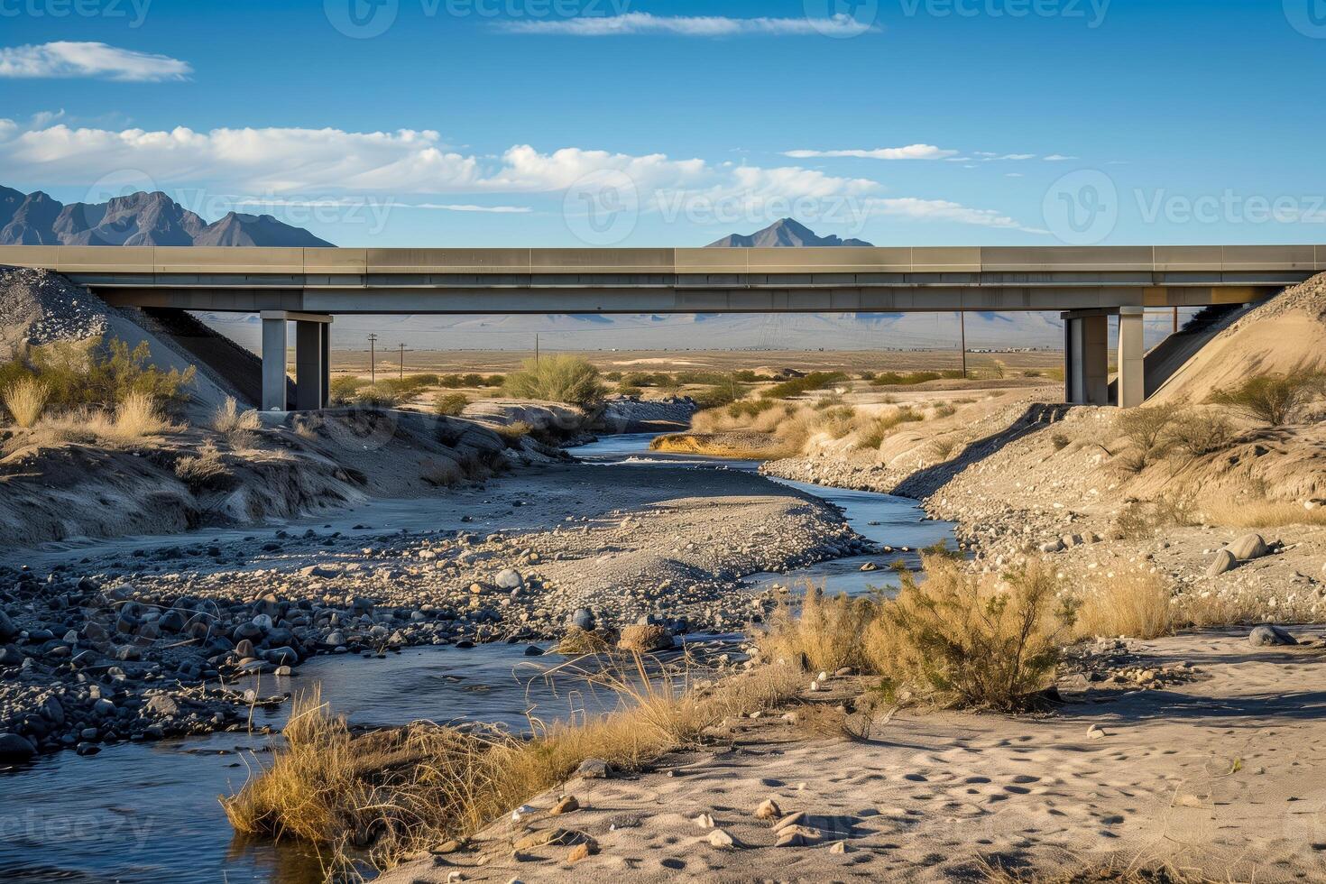 Bridge over river in desert with mountain backdrop photo