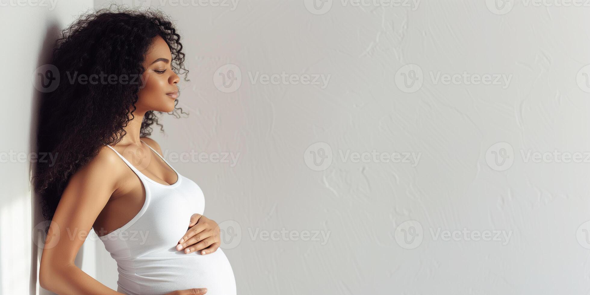 Pregnant black woman in a white tank top in profile photo