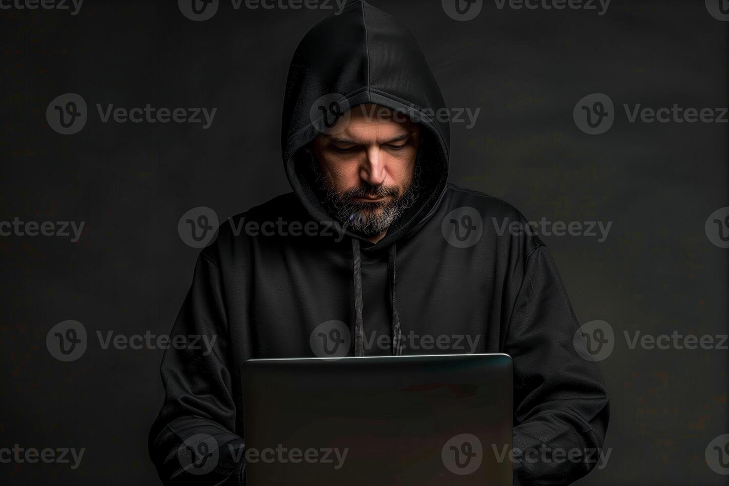 Man in a black hoodie using a laptop computer photo