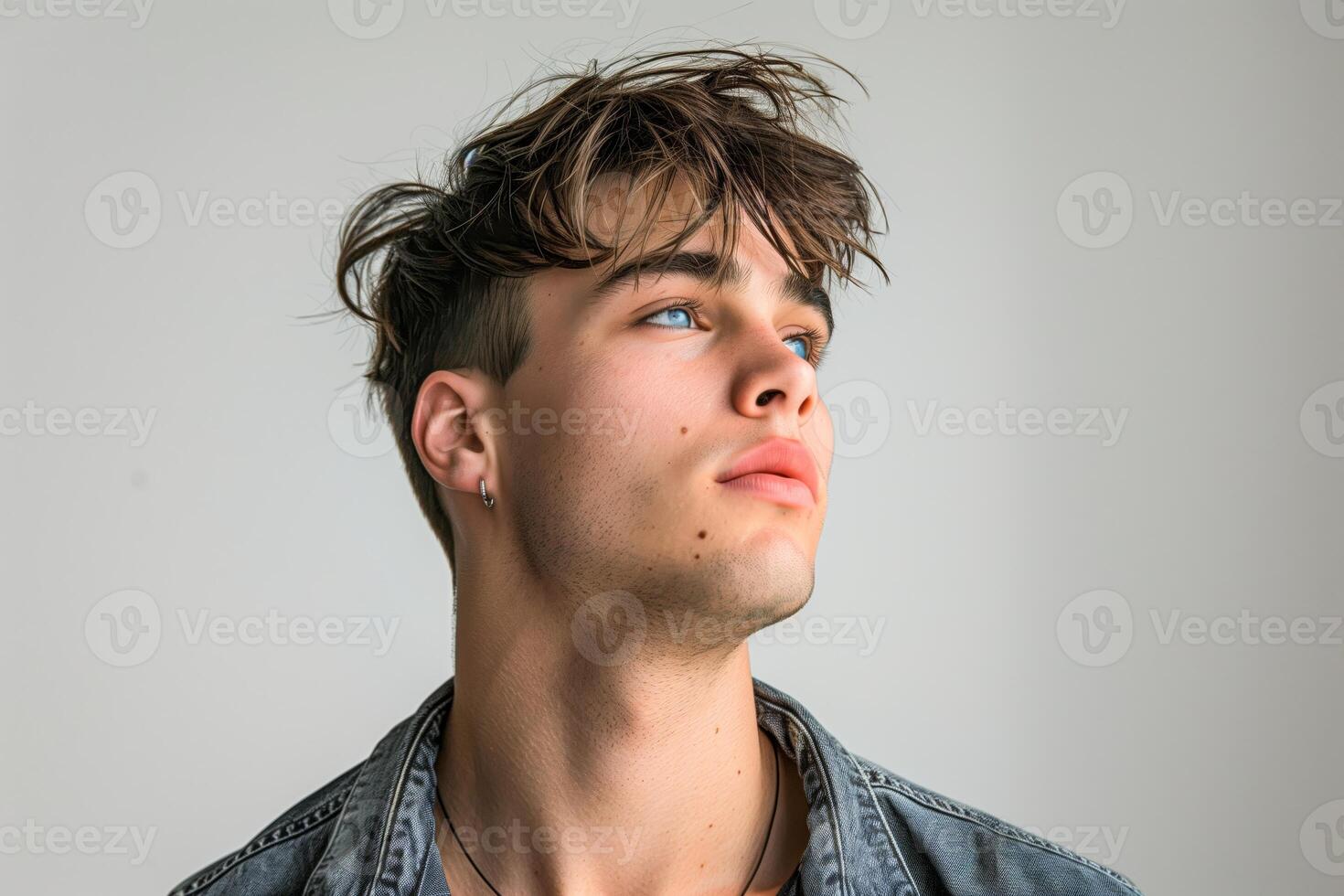 Man in blue shirt and necklace gazing upwards photo