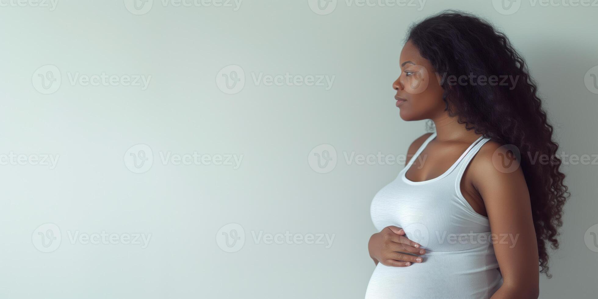 Pregnant black woman in a white tank top in profile photo